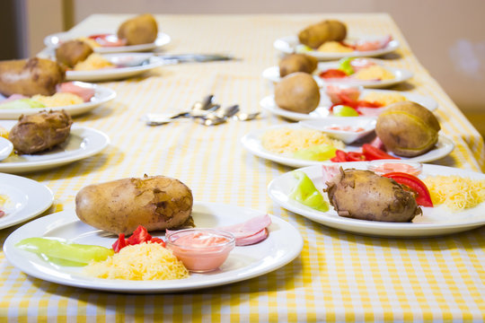 Alchevsk, Ukraine - July 16, 2017: Children's master class on cooking potatoes in the oven with ham and cheese