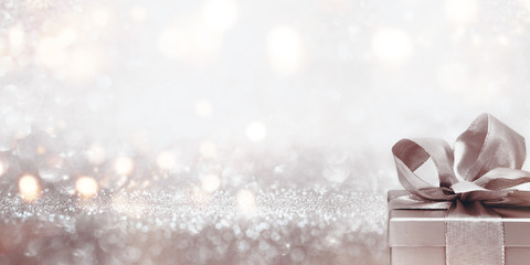 Gift on abstract silver glitter bokeh background