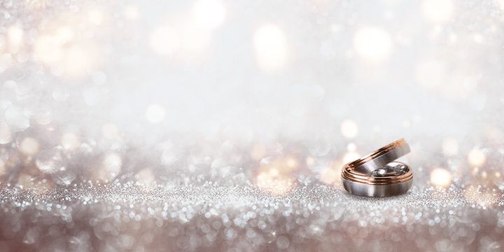Wedding rings on an abstract silver glittering bokeh background