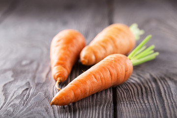Three bright juicy carrots with green cuttings