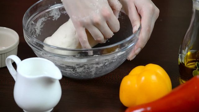 Female hands making dough on pizza