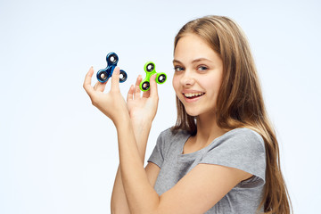 Young beautiful woman on white isolated background holds spinners