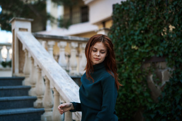 Young beautiful woman is walking along the street in the city