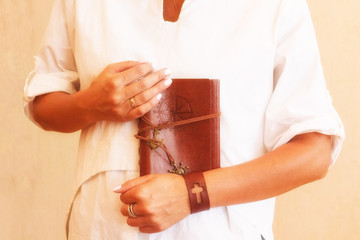 A brown travel journal imprinted with a compass rose in hand