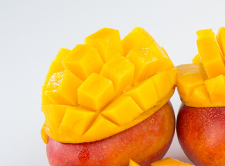 mango fruit and mango cubes in a bamboo basket isolated on white background
