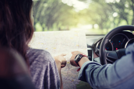 Asian man and woman using map on road trip and Happy young couple with a map in the car. Blurred and Soft focus
