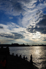 White nights, silhouettes of people on the embankment river on the background of the sunset sky 
