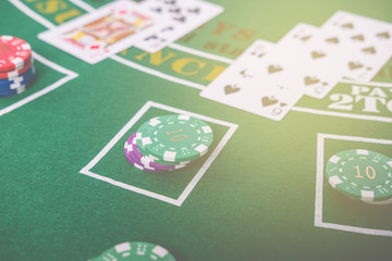 Gambling chips and cards on a green cloth Casino table