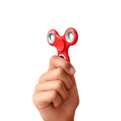 Red hand spinner. Boy playing a popular toy fidget spinner in his hand. Stress relief. Anti stress...