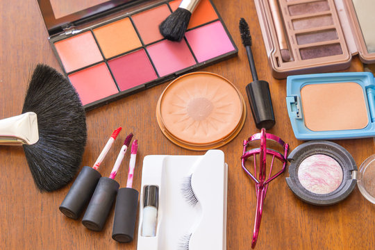 Makeup brushes and cosmetics isolated on wood, Various makeup brushes,   Different makeup cosmetics on table background.