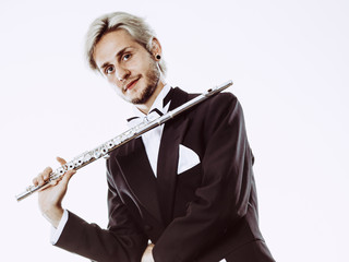 Male flutist wearing tailcoat holds flute