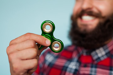 Young hipster man holding a fidget spinner toy