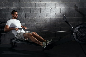 Fitness young man using rowing machine in the gym © ProstoSvet