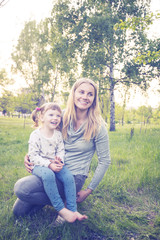 Fototapeta premium Young mother and her little daughter are enjoying life in park