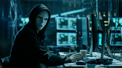 Masked Hacker is Using Computer for Organizing Massive Data Breach Attack on Corporate Servers....