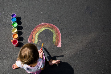 Girl painting rainbow on floor, overhead view