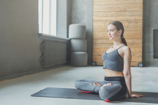 Young attractive woman practicing yoga sitting in padmasana