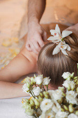 Obraz na płótnie Canvas Woman having massage in the spa salon. Body care. Flower in hair