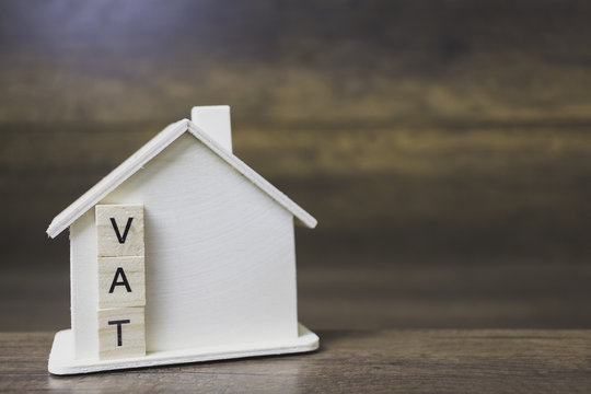 House model with vat word on wooden blocks.