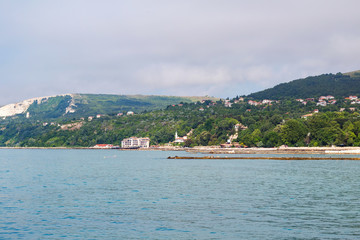 Fototapeta premium Cityscape view of balchik city houses and apartment buildings on the hills of black sea coast in Bulgaria