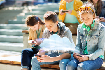 teenage friends with smartphones outdoors