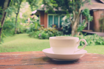 White coffee cup in the garden. (vintage tone)