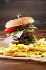 fresh tasty burger and french fries on wooden table