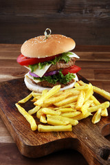 fresh tasty burger and french fries on wooden table