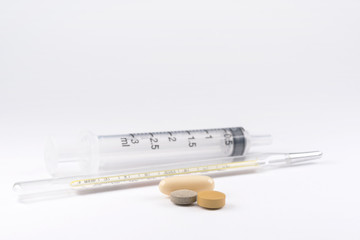 Medications, thermometer and syringe