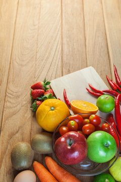 Healthy concept with mixed fruits and vegetables on wooden background