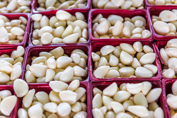 Closeup of peeled garlic cloves in baskets in farmers market display