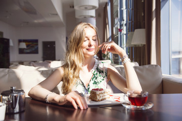 Pretty Young Woman Sitting in the Cafe with a Cup of Tea. Looking in the Window