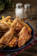Baked chicken wings with french fries.