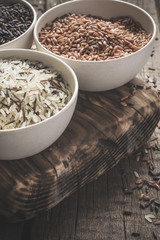 collection of different varieties of rice on wooden rustic background