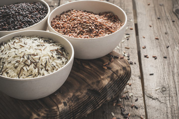 collection of different varieties of rice on wooden rustic background