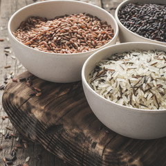 collection of different varieties of rice on wooden rustic background