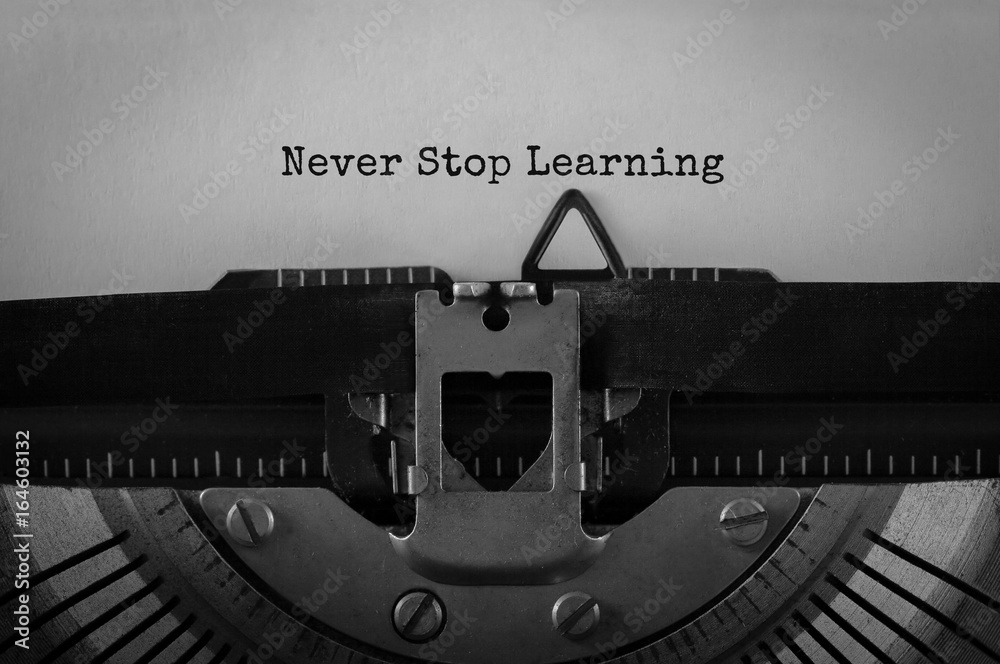 Fototapete text never stop learning typed on retro typewriter