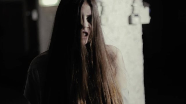 Female zombie attacking and killing man walking in garage slow motion closeup
