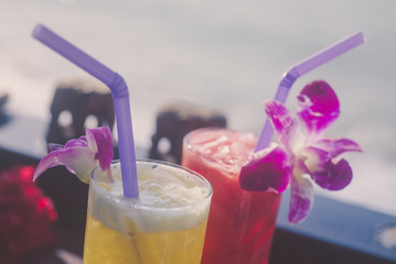 Two glasses of watermelon juice and a tropical flower