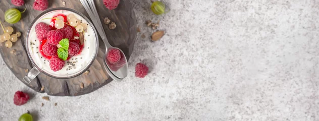 Fototapete Dessert Gesundes Sommerdessert mit Himbeeren und Joghurt auf dem Schneidebrett. Bannerformat