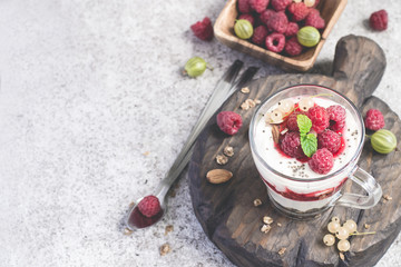 glass with raspberries, granola and yogurt arranged in layers