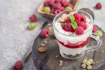 glass with raspberries, granola and yogurt arranged in layers