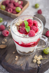 Dessert or breakfast with raspberries and yogurt in glass closeup