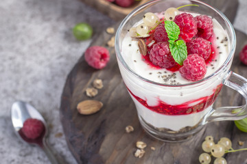 Dessert or breakfast with raspberries and yogurt in glass closeup