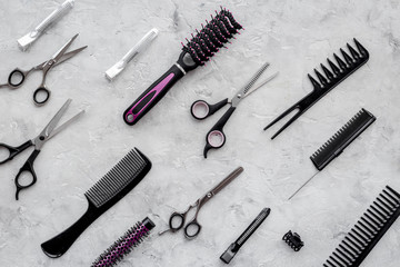 Pattern of combs and hairdresser tools on grey table background top view