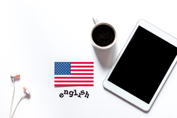 Naklejka premium Self-education. Learning english online. Headphones and tablet PC on white table background top view copyspace