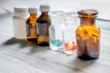 Vitamins and supplements. Pills and pill bottle on grey wooden table background