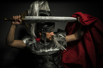 Gladiator, Roman centurion with armor and helmet with white chalk, steel sword and long red cape
