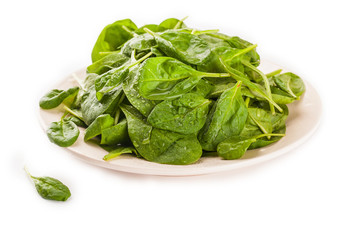 A fresh green spinach leaf isolated against a white background
