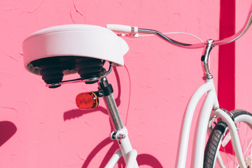 Fototapeta na wymiar Details of female urban bicycle on a background of pink wall